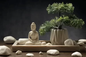 Arranjo de jardim zen com bonsai, pedras brancas e estátua de Buda
